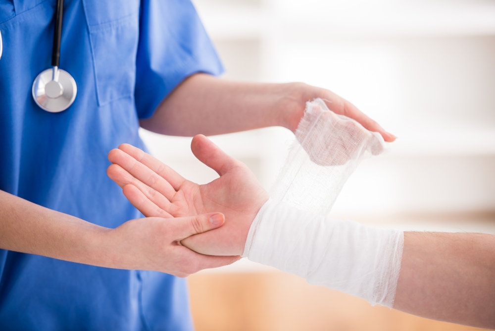 Cairns disability services nurse applying a bandage to a person's writs