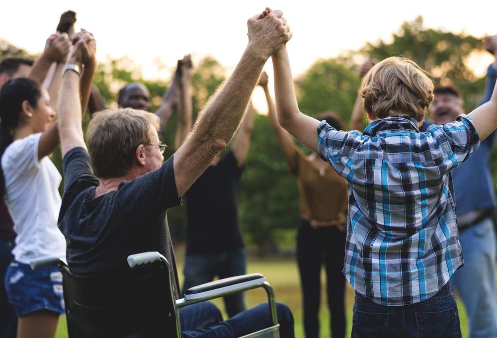 Group of people holding hands in Cairns outdoor community participation program