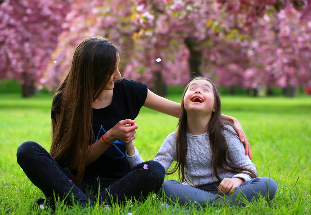 2 women sitting on a grass