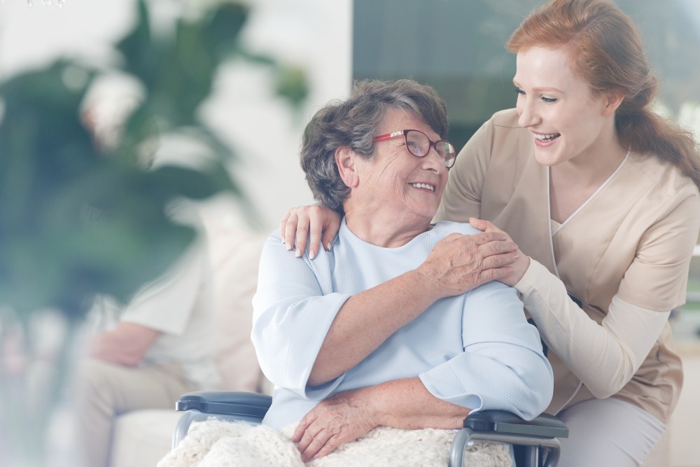 Happy NDIS recipient holding caregiver's hand