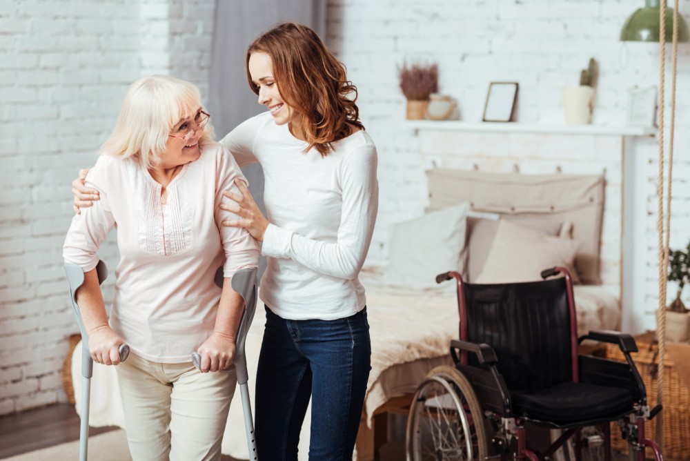 Cairns In Home Support worker assisting a lady on crutches